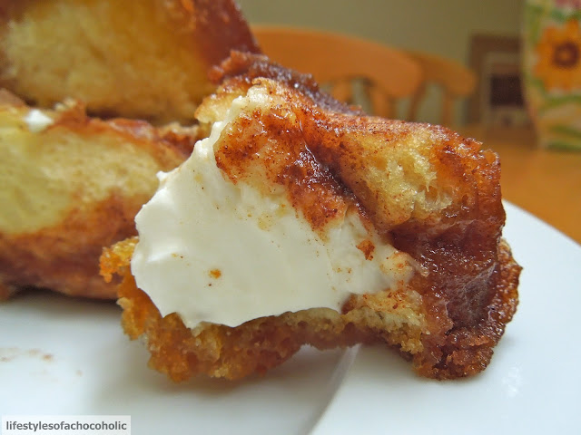 close up of cream cheese filled monkey bread on a white plate