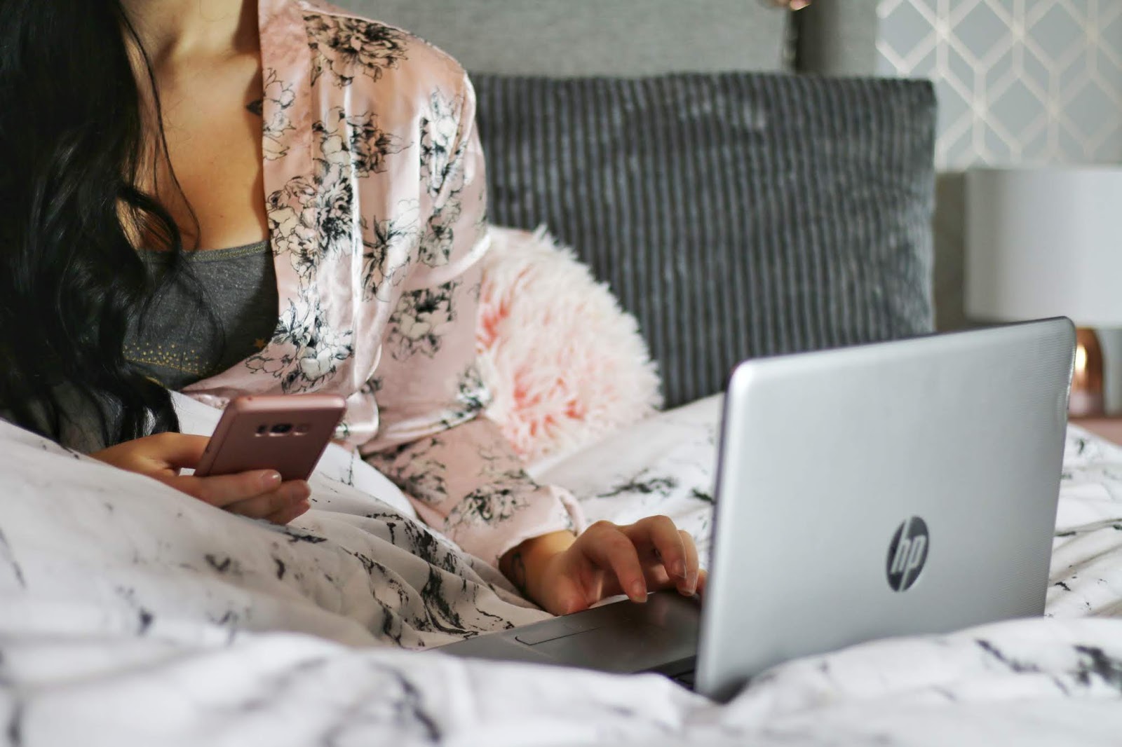 girl sitting in bed on phone and laptop girl sitting in bed on phone and laptop