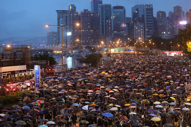 Manifestantes pró-democracia marcham em Hong Kong neste domingo (18).