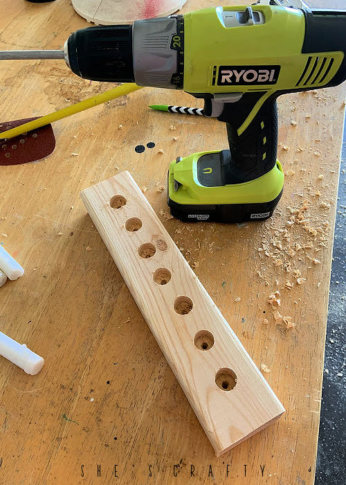 Drill holes in wood to make candle holder