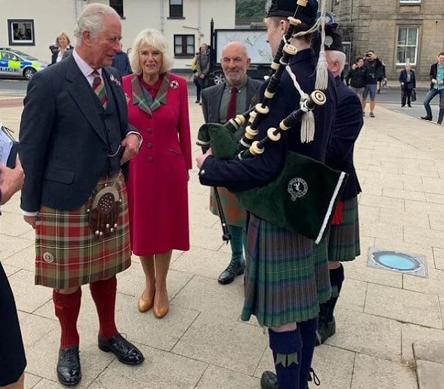 Duchess wore a waist-cinching red coat with a tartan lapel and tan heels. Camilla added a sapphire and diamond brooch