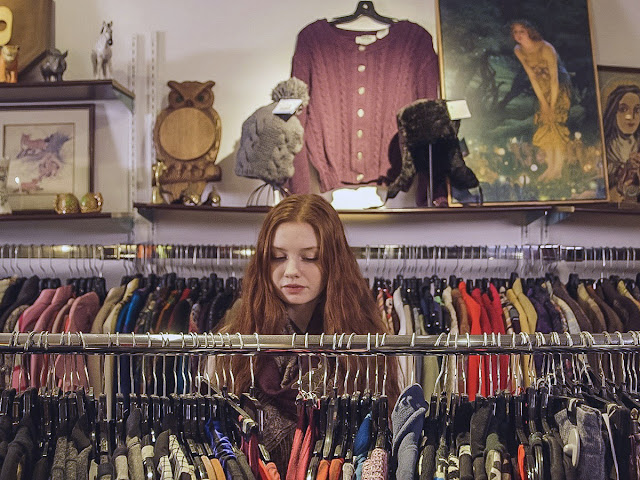 Woman checking out clothes on hangers in a store