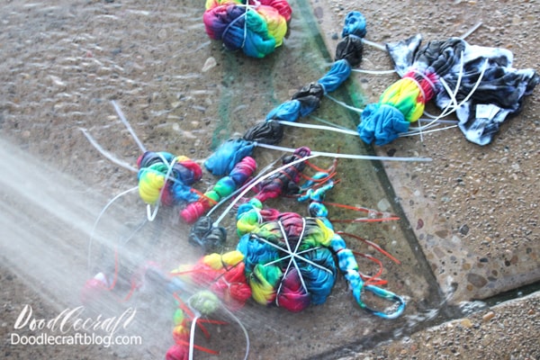 Then remove them and spray them off with the hose to remove any excess dye. Carefully clip off the rubber bands and zip ties and continue spraying them until the water runs clear. This can be done inside in the sink, but outside is so much more fun. 