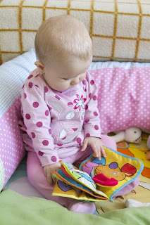 baby looking at a fabric book