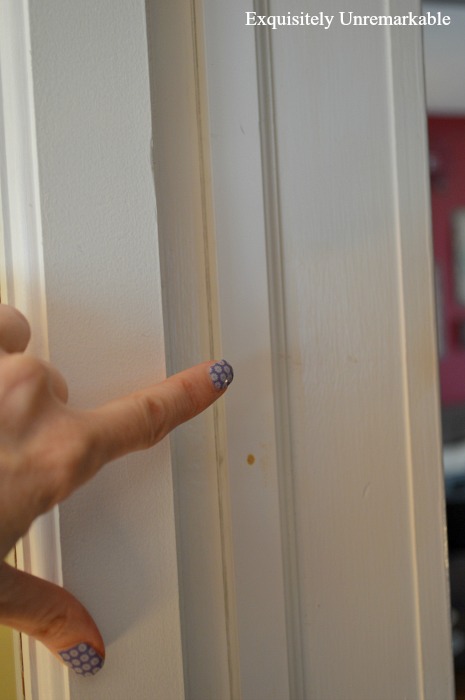 Hand with blue fingernail paint pointed out PVC door moulding