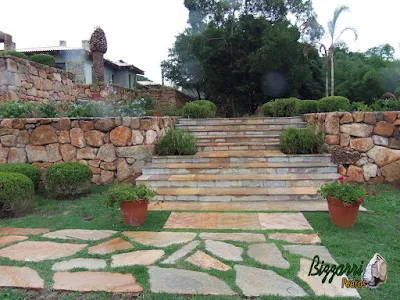 Execução do caminho no jardim com pedra Goiás com juntas de grama com execução da escada de pedra Goiás serrada com execução do paisagismo em residência em Piracaia-SP.