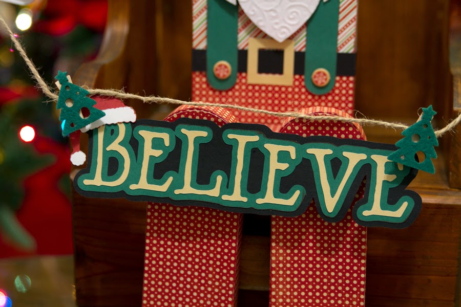 Close of sign Santa is holding that says Believe