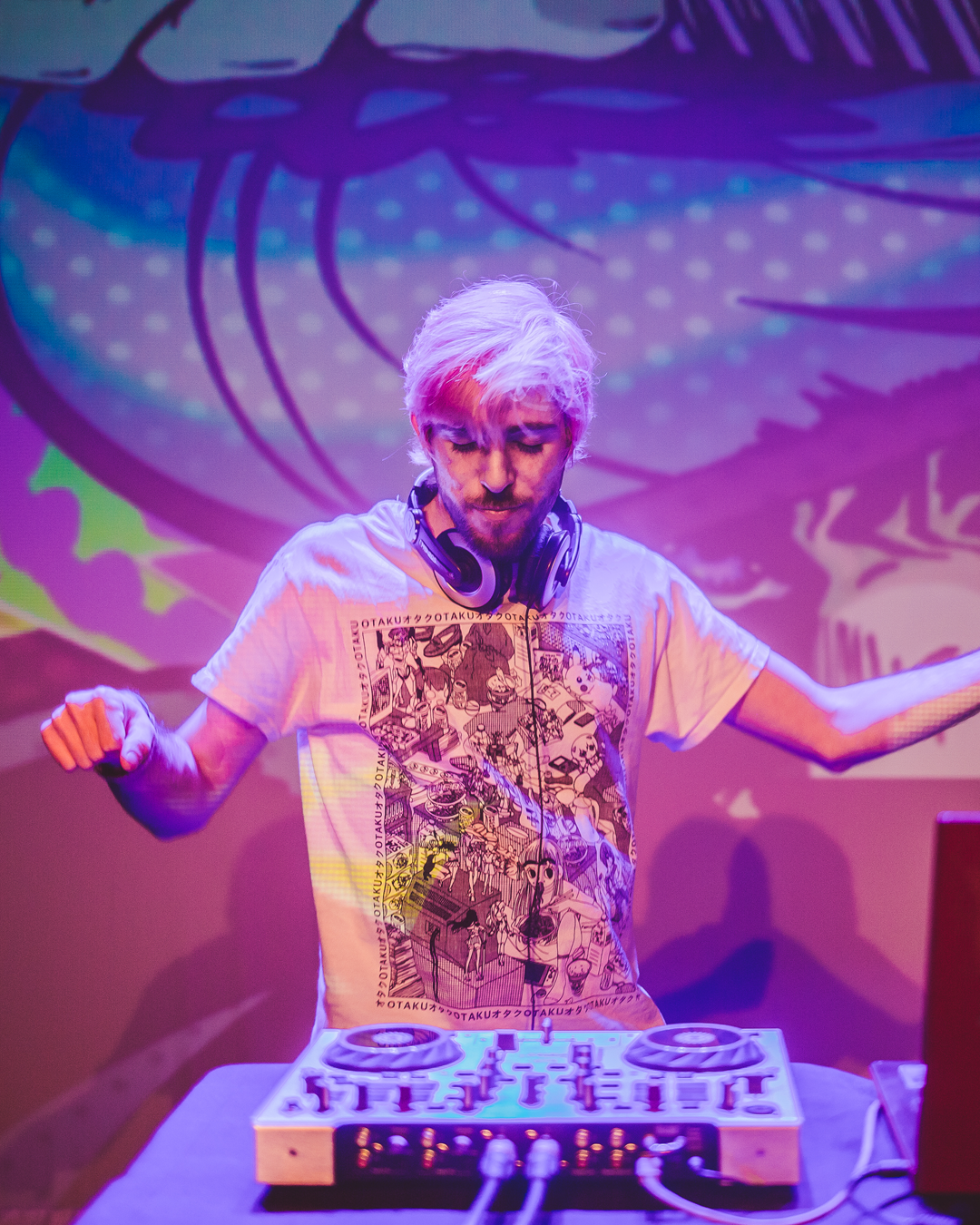 Un DJ con el pelo rosa haciendo de DJ y una imagen de Jotaro de Jojos Bizarre Adventure de fondo