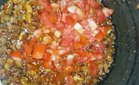 Adding and frying chopped tomatoes for chicken curry recipe