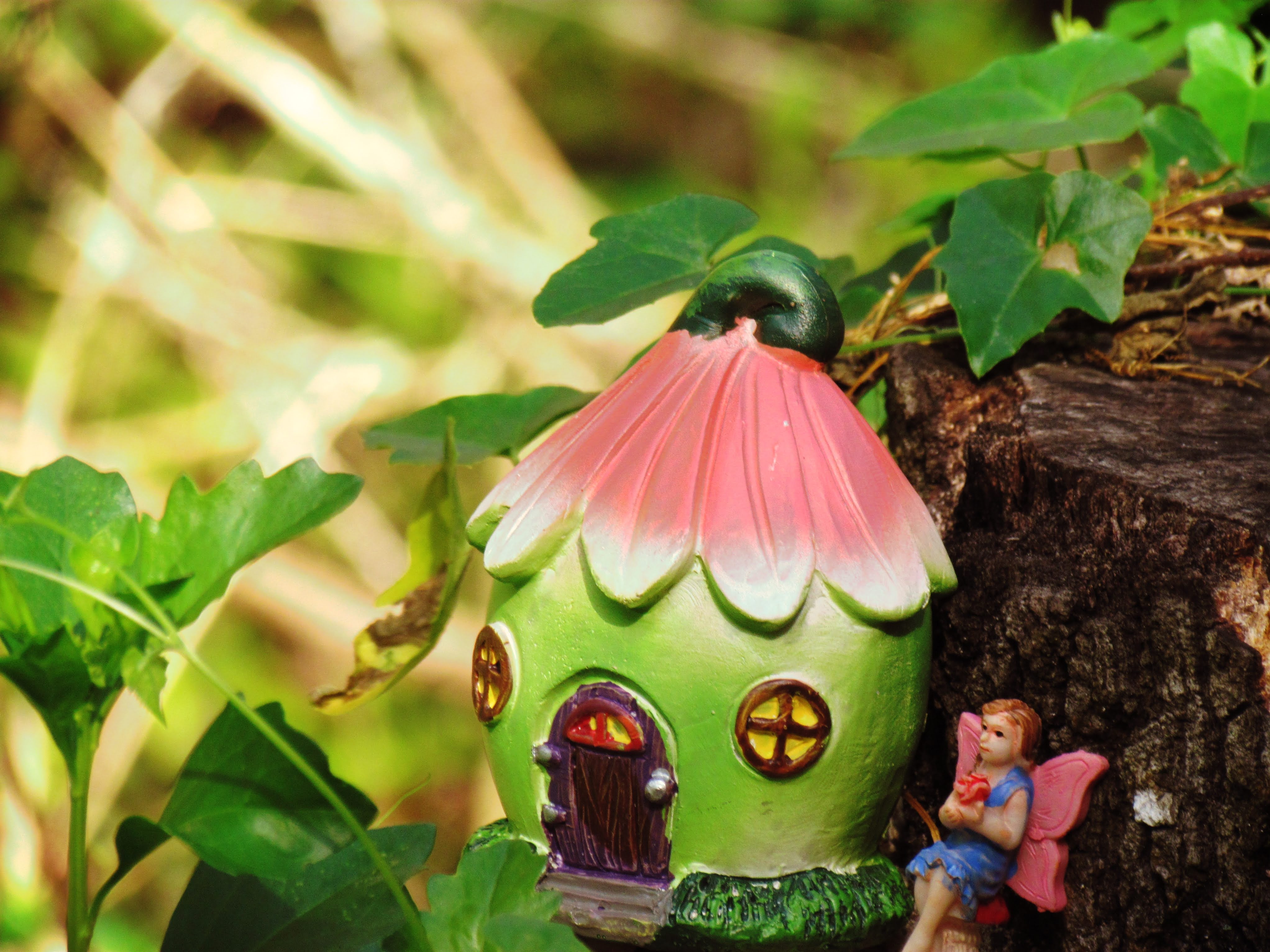 A fairy and quaint fairy cottage sitting on a mushroom in the forest with green and pink energies