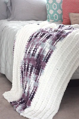 knit throw blanket on a bed.