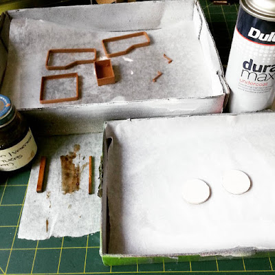 One-twelfth scale miniature kit pieces for an Alvar Aalto trolley 900, stained, painted or varnished and laid out to dry.