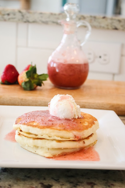 pancakes topped with whipped cream and homemade strawberry syrup