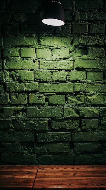 Green wall, bricks, wooden table, lamp, lighting