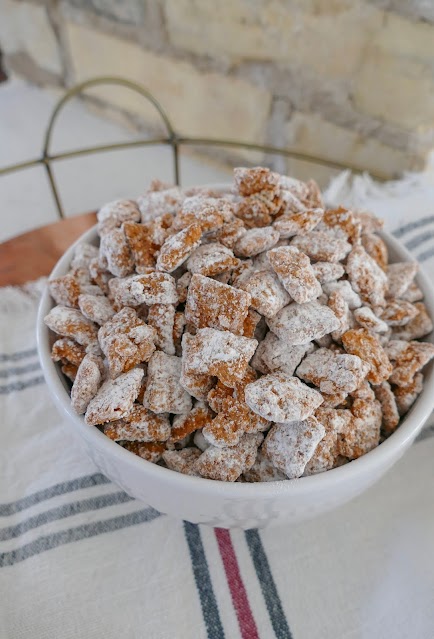 Muddy Buddies in a white bowl with striped napkin.