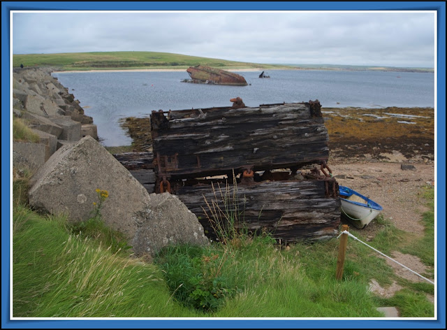 Restos de los cajones que se utilizaron para construir las barreras y barco hundido