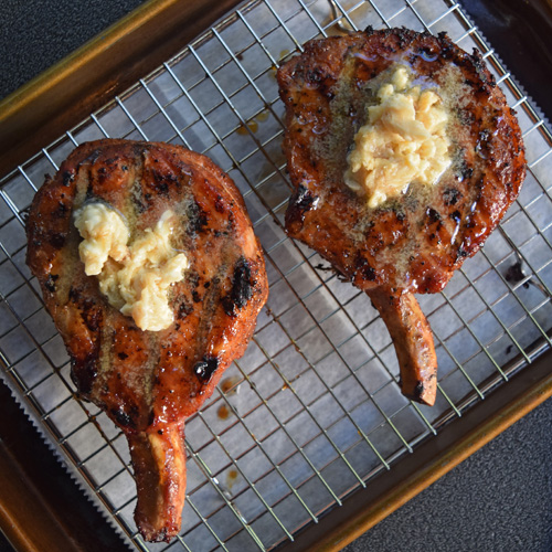 Bourbon Brown Sugar Pork Chops resting on a wire resting rack