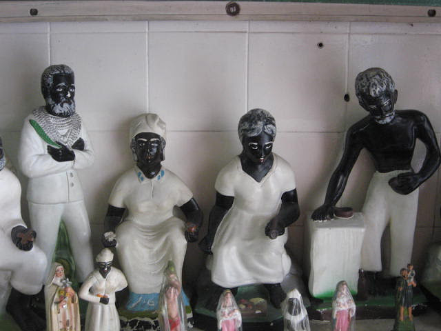 Маленькие умбандийские статуи претос велос или «старых рабов», духов умерших порабощенных. Статуи олицетворяют страдание, сострадание, прощение и надежду.