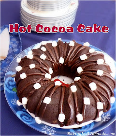 Hot Cocoa Cake is a dense chocolate winter dessert made with hot cocoa and garnished with mini marshmallows. | Recipe developed by www.BakingInATornado.com | #recipe #cake