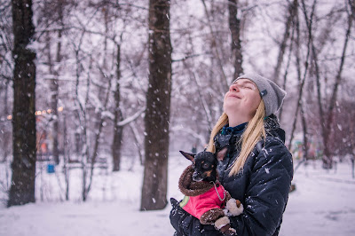 woman holding a dog in snow