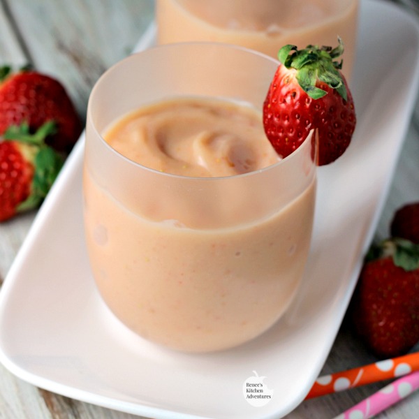 Easy Strawberry Mango Smoothies | by Renee's Kitchen Adventures in white glasses on a white platter with fresh strawberry garnish