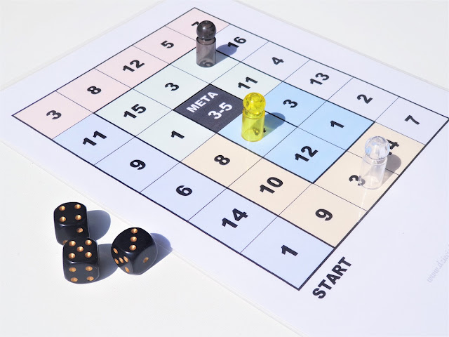 gra na lekcje matematyki gra matematyczna do wydruku, na zdjęciu cała plansza do gry, na niej trzy pionki w kolorach czarny, biały i żółty, pionek żółty jest jedno pole przed metą, obok leża trzy kostki z wartościami 5,4,3