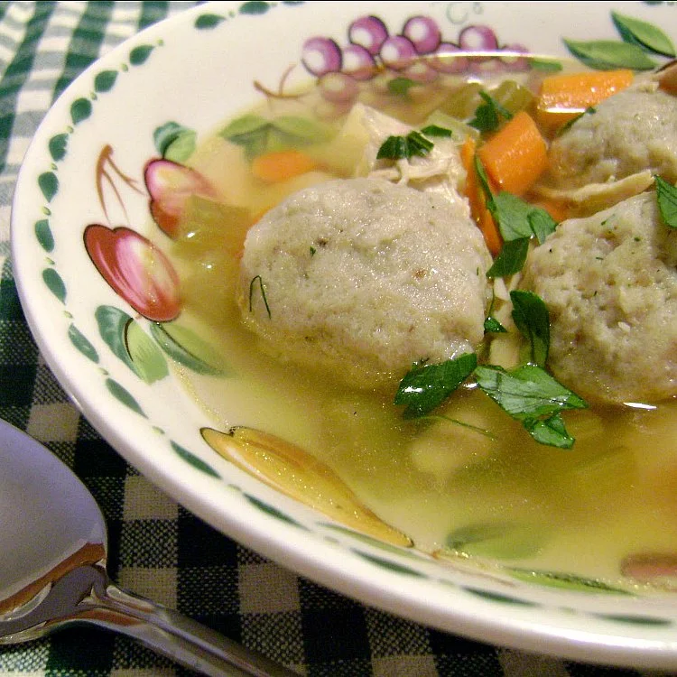 Chicken Soup with Mini Matzo Balls by Renee's Kitchen Adventures in bowl with spoon and green and white checked background
