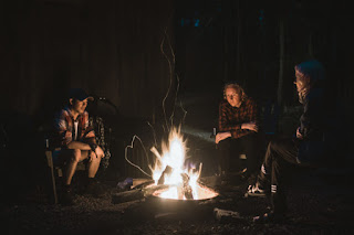 Jóvenes reunidos en torno a una hoguera.