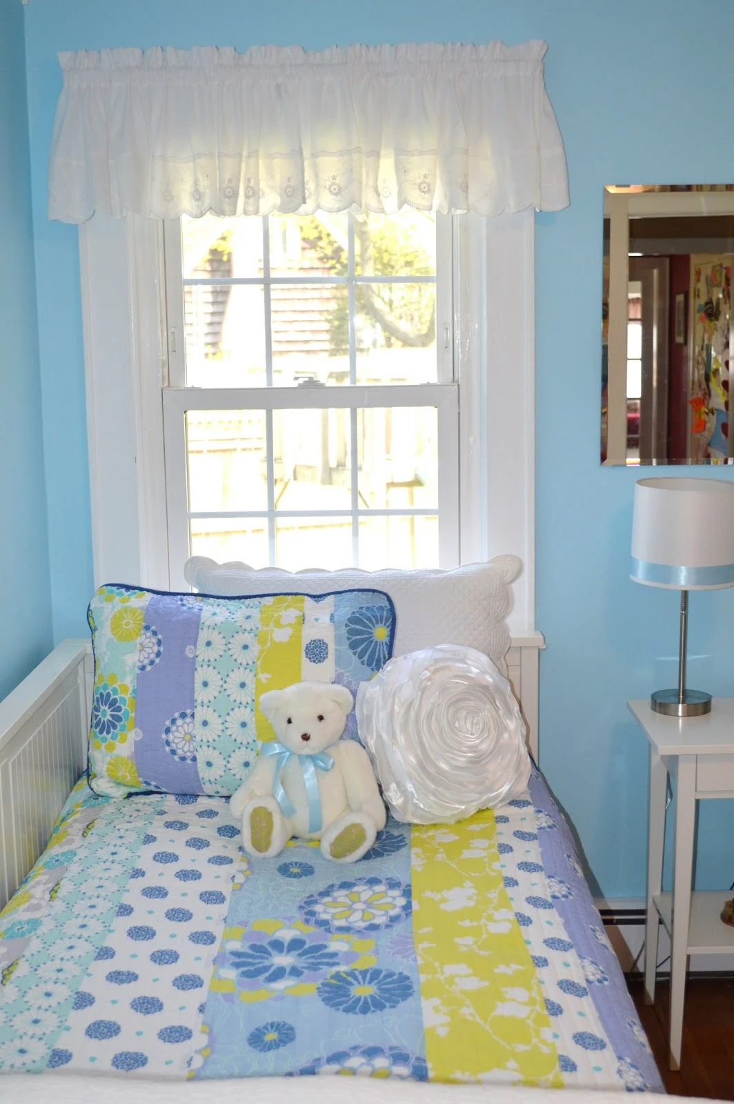 Blue bedroom for girls with teddy bear and floral pillow