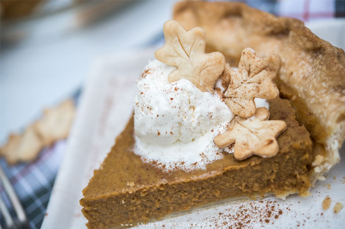 Piece of pumpkin pie with whipped cream and dough leaves