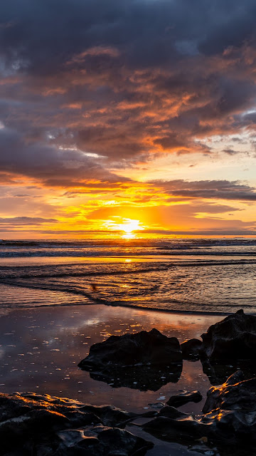 Beautiful sunset clouds, beach, stones, skyline