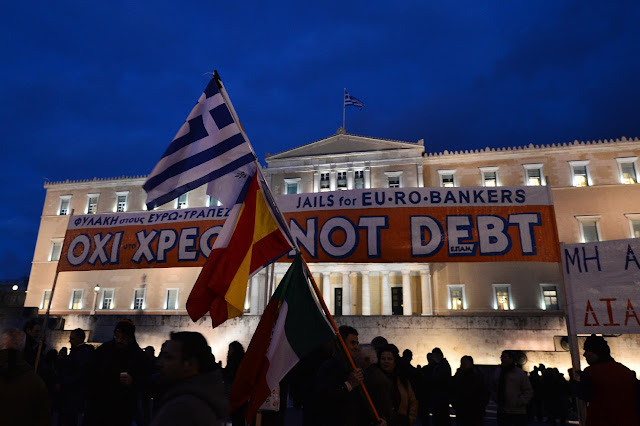Greeks demonstrate in front of the country's parliament on February 16, 2015 in a pro-government demonstration after Athens rejected an initial EU bailout offer as "absurd" and "unacceptable" (AFP Photo/Louisa Gouliamaki) Banner written in Greek and English reads: Jail for Euro Bankers Not Debt