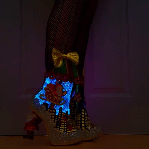 light up Christmas ankle boots being worn in very dark room with silhouette of Santa sleigh