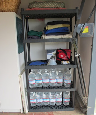 emergency supplies, mostly water, in garage on shelves