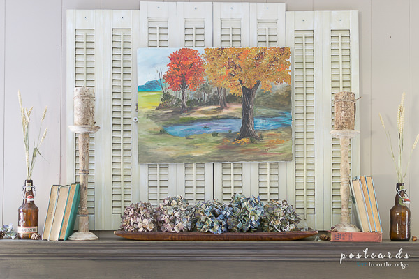 vintage fall themed oil painting on mantel