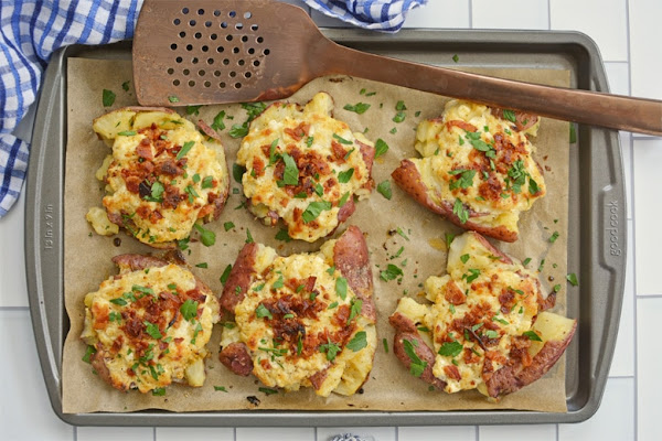 Top view of crab smashed potatoes on a baking sheet.