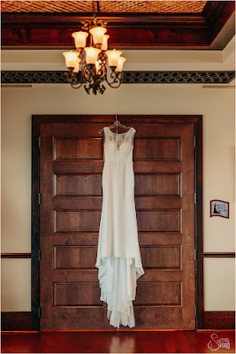 wedding dress hanging on door