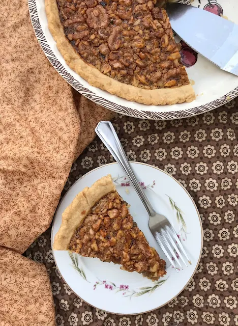 Honey walnut pie with a slice on a small plate.
