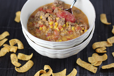beef, corn and tomato soup in a bowl with fritos around it