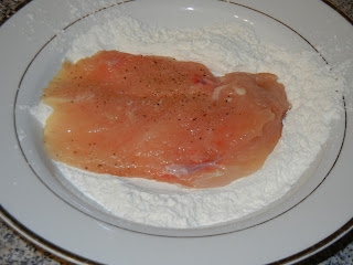 raw chicken breast on a plate with flour 