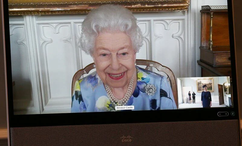 Queen Elizabeth wore a pale blue floral dress, with a three-string pearl necklace and a diamond brooch