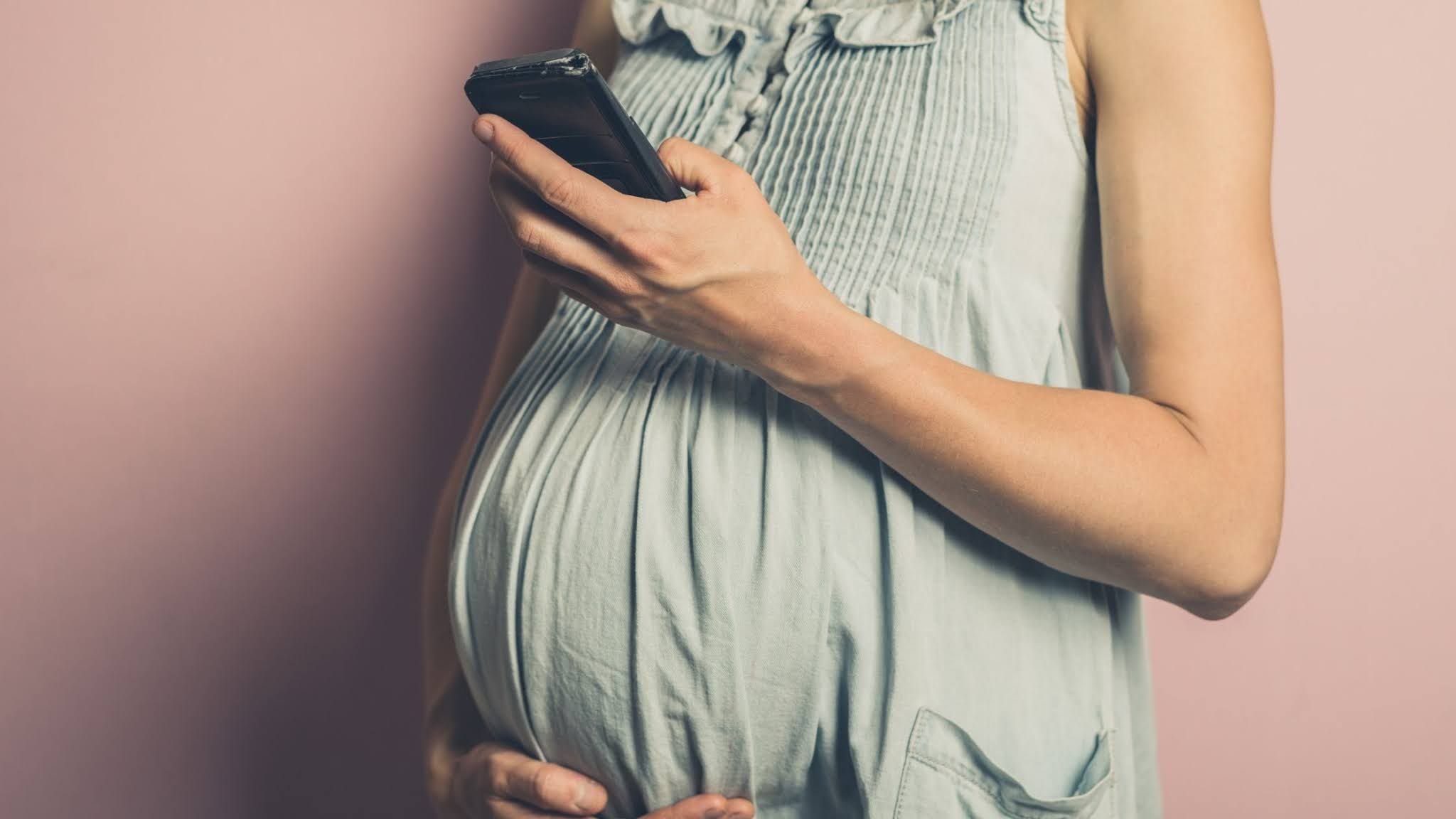 роженица с ноутбуком. беременная мобильниками. красивые молодые беременные девушки. Pregnant looking in tablet screen. беременная с ноутбуком.