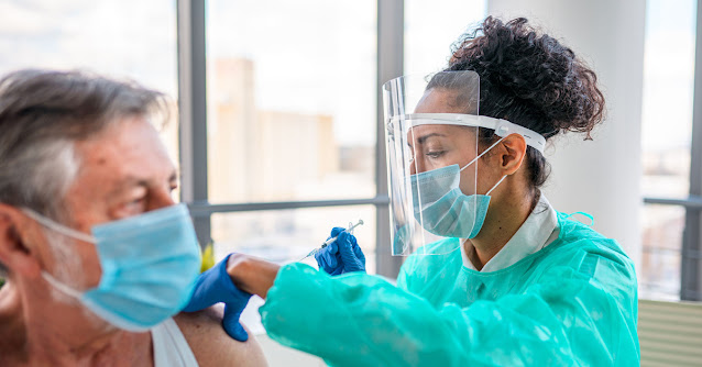 nurse injects a vaccination into a patient