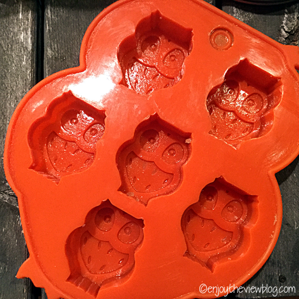 orange silicone owl molds on a wooden table