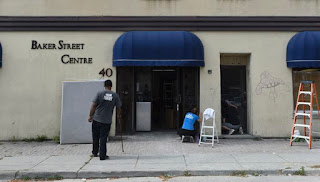 Workers clean the front of the building at 40 Baker Street on Wednesday afternoon. The Church of Scientology is moving into the building, renting out the office space and turning it into a headquarters for Scientology activities in Canada. 