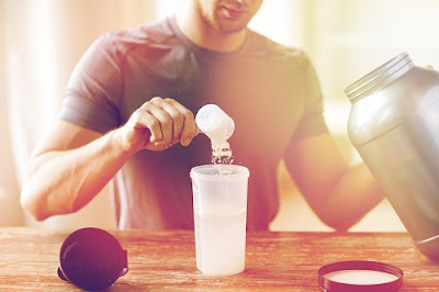 Man Putting Protein Powder in Shake