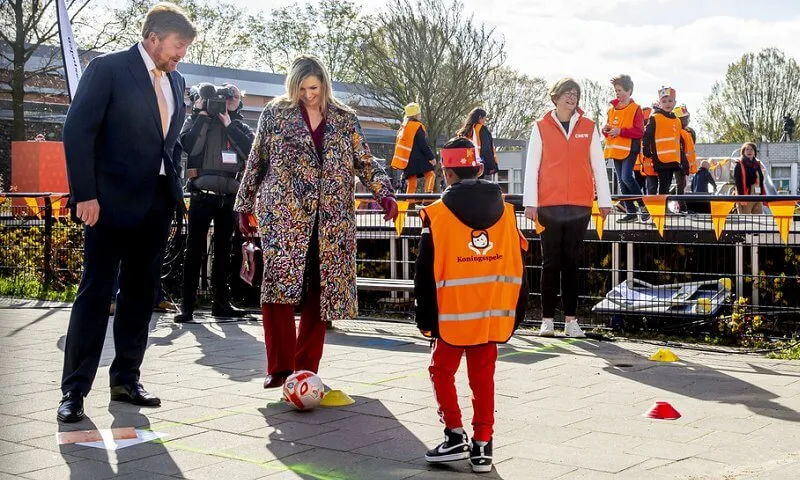 Queen Maxima wore a floral brocade long coat from Oscar de la Renta, and red LaPerm blazer, Lykoi trousers and Korat red blouse from Claes Iversen