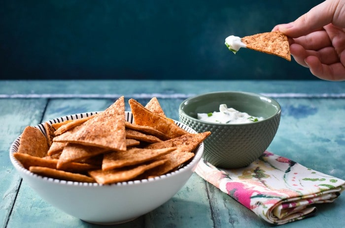 A tortilla dip scooping up lemon chive dip