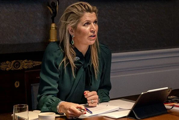 Queen Maxima wore an emerald green silk blouse by Gucci. emerald earrings