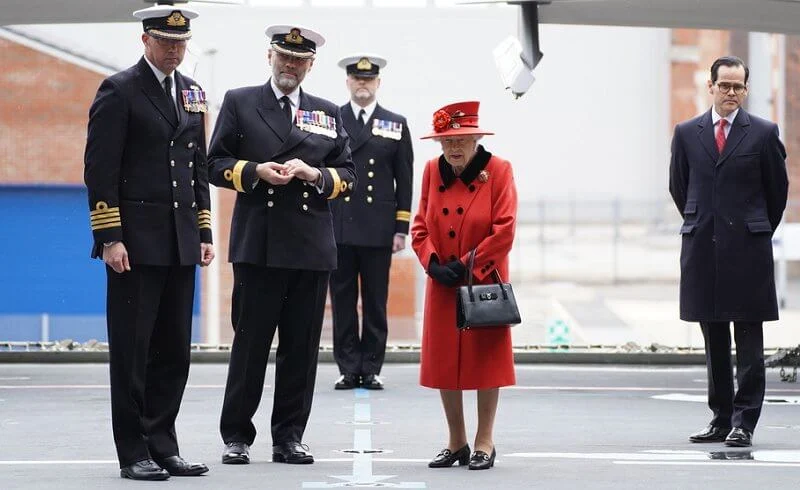 Queen Elizabeth wore a red coat, gold diamond brooch. HMS Queen Elizabeth and sister aircraft carrier HMS Prince of Wales